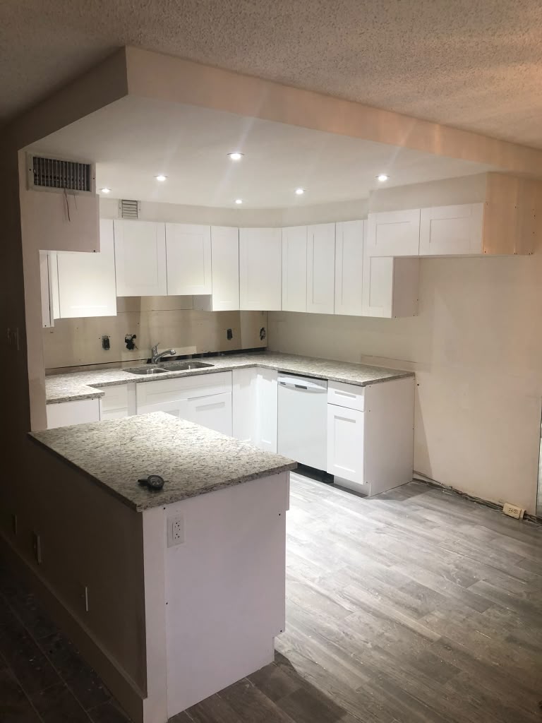 After: kitchen with white cabinets and new granite counters