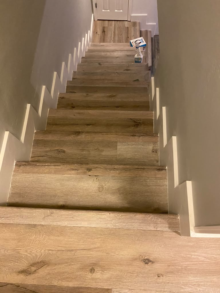 After: staircase stripped to subfloor and then finished with new wood-look treads